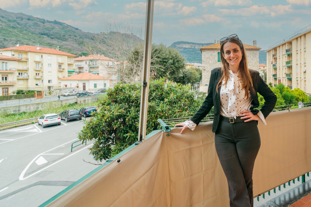 Immagine attuale: Lucrezia Ottonello, agente immobiliare Agecasa a Finale Ligure, su un balcone di un immobile
